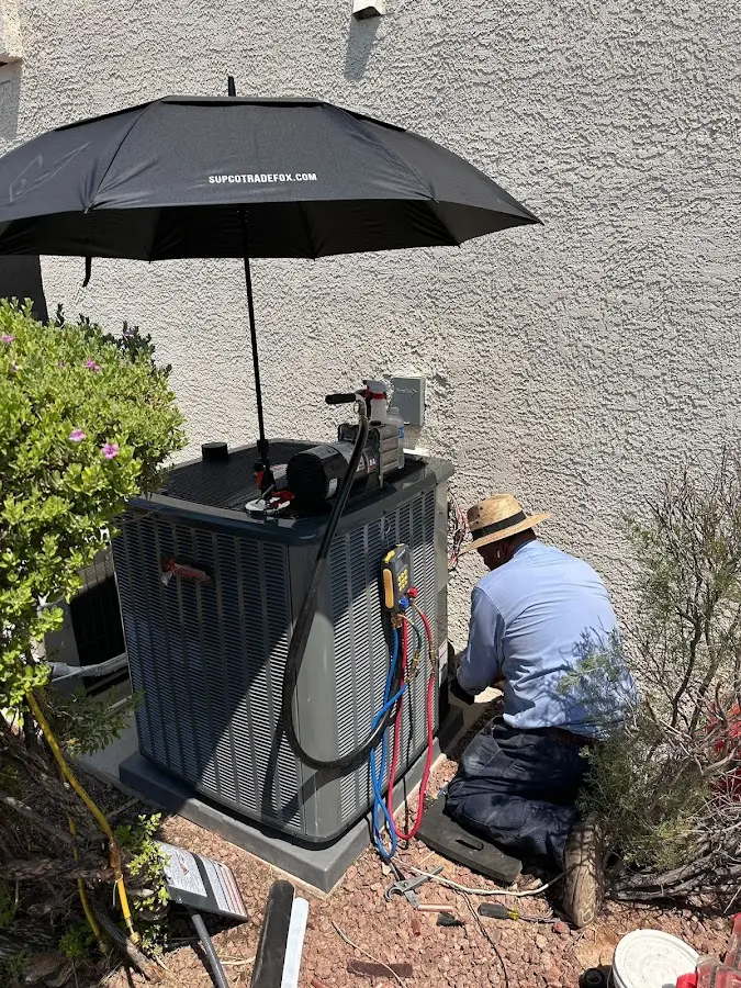 HVAC technician performing outdoor AC maintenance in Killingworth