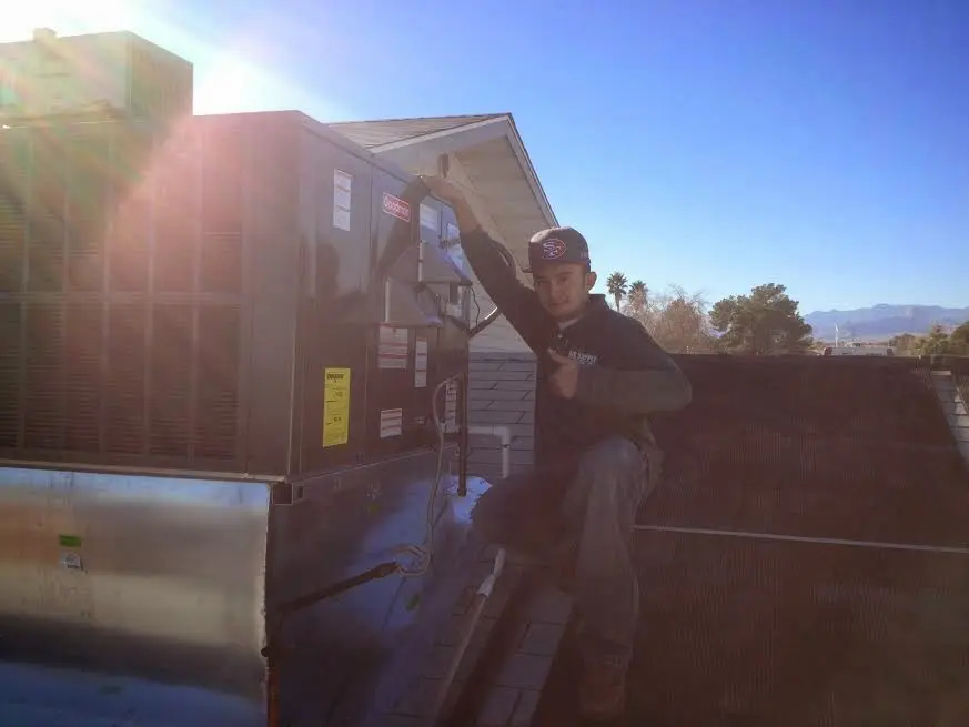 HVAC technician performing AC Tune-Up on a rooftop unit in Killingworth